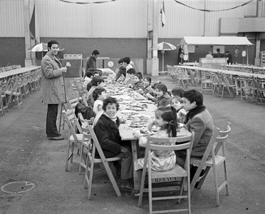 855125 Afbeelding van lange tafels met etende bezoekers van de 'Arabische Feesten', in de veemarkthallen (Sartreweg) te ...